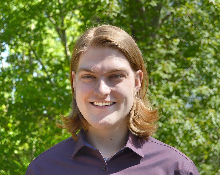 Luke Isenga on a green backdrop smiling