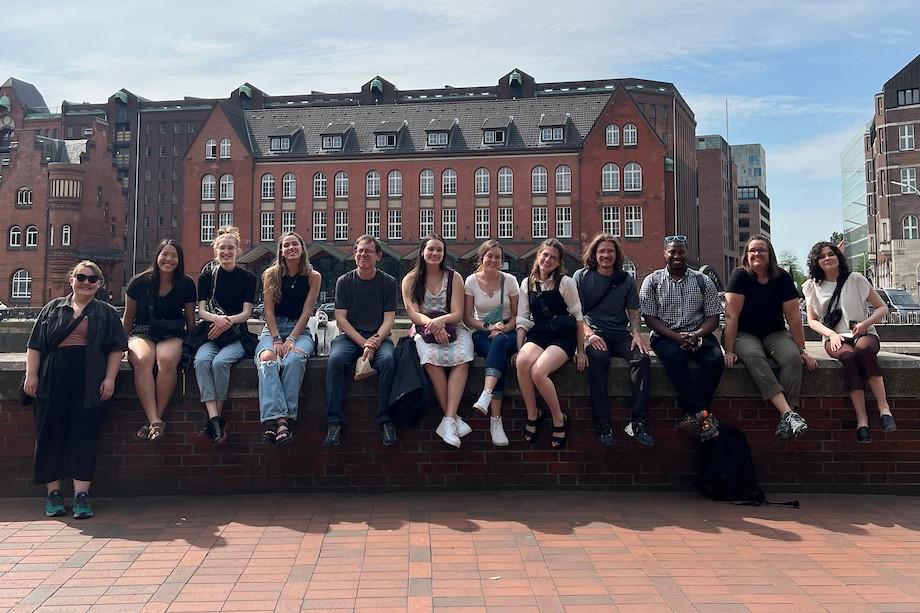 Students sitting in a line on a wall in 德国y