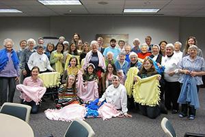 Students holding handmade blankets